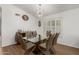 Bright dining room boasts a glass table, wood floors, modern lighting and plantation shutters at 20424 N 96Th Ln, Peoria, AZ 85382