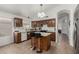 Charming kitchen features an island with bar seating, warm-toned cabinets, and tile flooring at 20424 N 96Th Ln, Peoria, AZ 85382