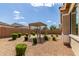 Landscaped backyard with gravel, trimmed bushes, and a pergola for relaxation and shade at 21031 E Poco Calle St, Queen Creek, AZ 85142