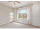 Bedroom showcases a light-filled window with views of the backyard, accent wall, and door to outside at 21031 E Poco Calle St, Queen Creek, AZ 85142