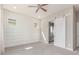 Light filled bedroom features a ceiling fan, plush carpet, accent wall, barn door to ensuite bathroom at 21031 E Poco Calle St, Queen Creek, AZ 85142
