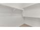 Walk-in closet with ample shelving and storage space, painted in a bright white color at 21031 E Poco Calle St, Queen Creek, AZ 85142