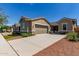 Charming single-story home showcasing a wide driveway and a two-car garage at 21031 E Poco Calle St, Queen Creek, AZ 85142