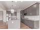 A well-equipped kitchen boasts stainless steel appliances, gray cabinets, a quartz countertop island, and modern lighting fixtures at 21031 E Poco Calle St, Queen Creek, AZ 85142