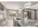 Bright kitchen with a large island, stainless steel sink, wood-look flooring, and sliding glass doors to the backyard at 21031 E Poco Calle St, Queen Creek, AZ 85142