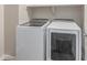 Well-equipped laundry room with modern, front-loading washer and dryer for convenience at 21031 E Poco Calle St, Queen Creek, AZ 85142