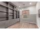 Office featuring a built-in bookcase, wood flooring, and a window with a woven shade at 21031 E Poco Calle St, Queen Creek, AZ 85142