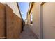 Side yard with gravel, block fence, and access door, offering functionality and security at 21031 E Poco Calle St, Queen Creek, AZ 85142