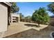 Backyard with covered patio, tree and perimeter fence at 21299 E Roundup Way, Queen Creek, AZ 85142