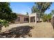 View of the backyard with covered patio, house, and mature trees at 21299 E Roundup Way, Queen Creek, AZ 85142