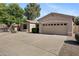 Attractive exterior of a single-story home featuring a well-maintained yard and a spacious two-car garage at 21299 E Roundup Way, Queen Creek, AZ 85142