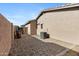 Home exterior features gravel side yard and air conditioning unit at 21299 E Roundup Way, Queen Creek, AZ 85142
