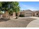 Charming single-story home showcasing desert landscaping, a spacious driveway, and a two-car garage at 21299 E Roundup Way, Queen Creek, AZ 85142