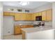 Well-lit kitchen featuring light wooden cabinets, granite countertops, and modern appliances at 21299 E Roundup Way, Queen Creek, AZ 85142