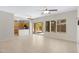 Open-concept living room and kitchen with tile flooring, a ceiling fan, and a sliding glass door at 21299 E Roundup Way, Queen Creek, AZ 85142