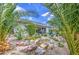 Private backyard with palm trees, rock water feature, and lush landscaping, providing a tranquil outdoor space at 21711 E Arroyo Verde Dr, Queen Creek, AZ 85142
