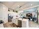Open-concept kitchen with white cabinets, stainless appliances, and a large island that flows into the living room at 21711 E Arroyo Verde Dr, Queen Creek, AZ 85142