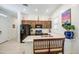 Stylish kitchen with modern black appliances, dark cabinets, and an eat-in island at 21711 E Arroyo Verde Dr, Queen Creek, AZ 85142