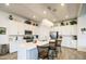 Bright kitchen boasts white cabinetry, quartz countertops, stainless appliances, and a large island with seating at 21711 E Arroyo Verde Dr, Queen Creek, AZ 85142
