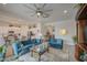 Cozy living room featuring blue sofas, an oversized ceiling fan, and open to kitchen at 21711 E Arroyo Verde Dr, Queen Creek, AZ 85142