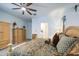 Spacious main bedroom with warm tones, a ceiling fan, and a glimpse into the en-suite bathroom at 21711 E Arroyo Verde Dr, Queen Creek, AZ 85142