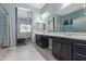 Ensuite bathroom featuring dual sinks, dark cabinetry, and direct access to the main bedroom at 2365 N Springfield St, Buckeye, AZ 85396