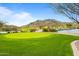 Scenic golf course view with a pristine green, water features and mountain backdrop at 2365 N Springfield St, Buckeye, AZ 85396