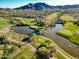 Picturesque aerial view of a lush golf course with ponds and mountain views at 2365 N Springfield St, Buckeye, AZ 85396