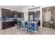 Modern kitchen with dark cabinetry, granite countertops, and a stylish blue backsplash at 2365 N Springfield St, Buckeye, AZ 85396