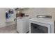 A modern laundry room with a washer, dryer, and storage shelves offers a practical space at 2365 N Springfield St, Buckeye, AZ 85396