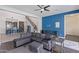 Inviting living room featuring a modern gray sectional sofa, ceiling fan and stylish decor with views to kitchen and staircase at 2365 N Springfield St, Buckeye, AZ 85396