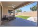 A covered back patio features a ceiling fan, seating, and an outdoor view of the lawn at 23730 W Hess Ave, Buckeye, AZ 85326