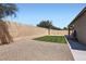 Backyard with a grassy area, a gravel area, a brick wall, and a concrete patio at 23730 W Hess Ave, Buckeye, AZ 85326