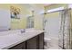 Bathroom with a single sink vanity with dark cabinets and quartz counters and a shower and tub combination at 23730 W Hess Ave, Buckeye, AZ 85326