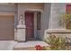Close up of the home's front door and entry with the house number and flowering bushes at 23730 W Hess Ave, Buckeye, AZ 85326