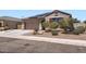 Single-story home with a two-car garage, low-maintenance front yard, and solar panels on the roof at 23730 W Hess Ave, Buckeye, AZ 85326
