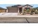 Inviting single-story home featuring a two-car garage, desert landscaping, and solar panels at 23730 W Hess Ave, Buckeye, AZ 85326