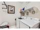 Laundry room with front-loading washer and dryer, white shelving, decor, and a painting at 23730 W Hess Ave, Buckeye, AZ 85326