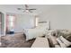 Bright main bedroom with a ceiling fan, carpeted floors, and a seating area at 23730 W Hess Ave, Buckeye, AZ 85326