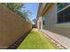 Narrow backyard featuring artificial turf and concrete block wall lined with a walkway of inlaid pavers at 2519 N 73Rd Dr, Phoenix, AZ 85035