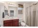 Bathroom featuring a single vanity, a window and shower with a curtain at 2519 N 73Rd Dr, Phoenix, AZ 85035