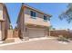 Two-story home features a 2-car garage, beige stucco, two windows and a private, gated side entrance at 2519 N 73Rd Dr, Phoenix, AZ 85035