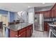 Open-concept kitchen with stainless appliances, wood cabinets, granite countertops, and a view of the stairway at 2519 N 73Rd Dr, Phoenix, AZ 85035