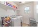 Well-lit laundry room with white appliances, shelving and a window at 2519 N 73Rd Dr, Phoenix, AZ 85035