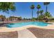 Community pool features palm trees, metal fencing and nearby townhomes in a sunny outdoor setting at 2519 N 73Rd Dr, Phoenix, AZ 85035