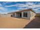 Exterior view of the home showing the covered patio and a large backyard with desert landscaping and block fencing at 262 S 164Th Dr, Goodyear, AZ 85338
