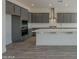 Well-equipped kitchen with stainless steel appliances, a large island, and elegant gray cabinets at 262 S 164Th Dr, Goodyear, AZ 85338