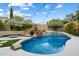Beautiful swimming pool with lush landscaping, rock features, a waterfall and a built-in fire pit area at 26264 N 46Th St, Phoenix, AZ 85050