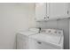 Functional laundry room with modern washer and dryer units, and white cabinetry at 2712 W Oakgrove Ln, Chandler, AZ 85224