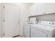 Functional laundry room with washer, dryer, and overhead cabinets for organized storage at 2732 E Tyson St, Chandler, AZ 85225